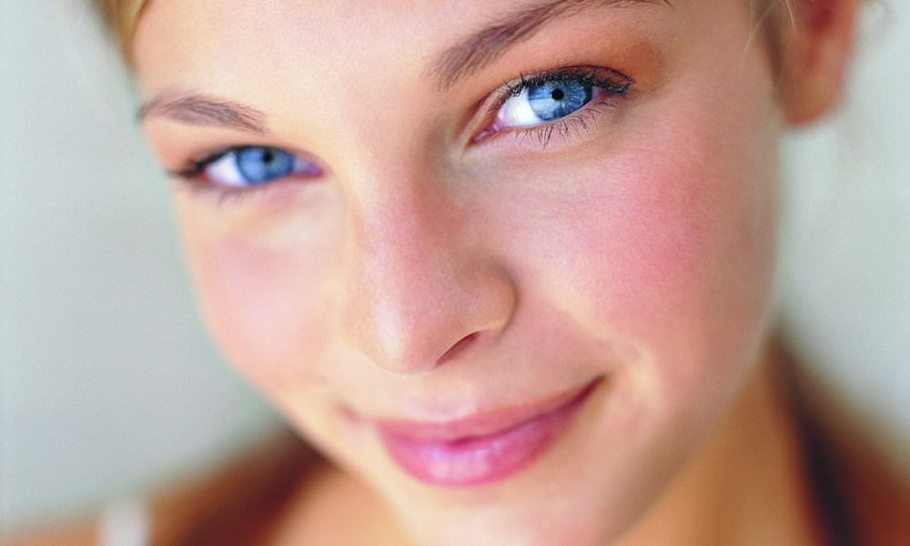 mulher com rosto avermelhado olhos azuis